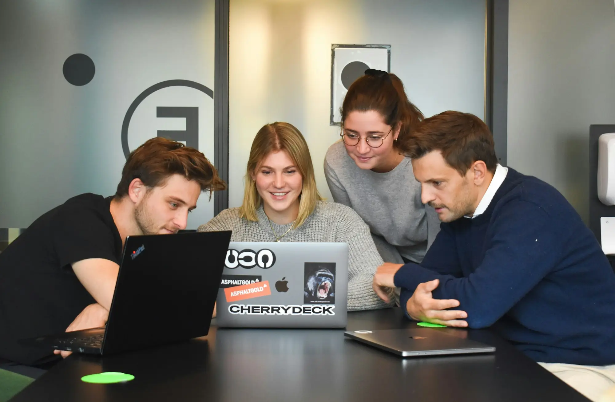 Four people from a digital agency collaborating around laptops